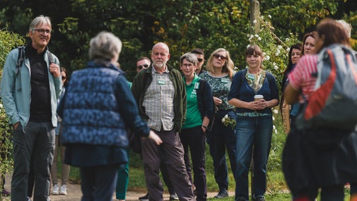 A group of people who are National Trust council members gathered together outdoors
